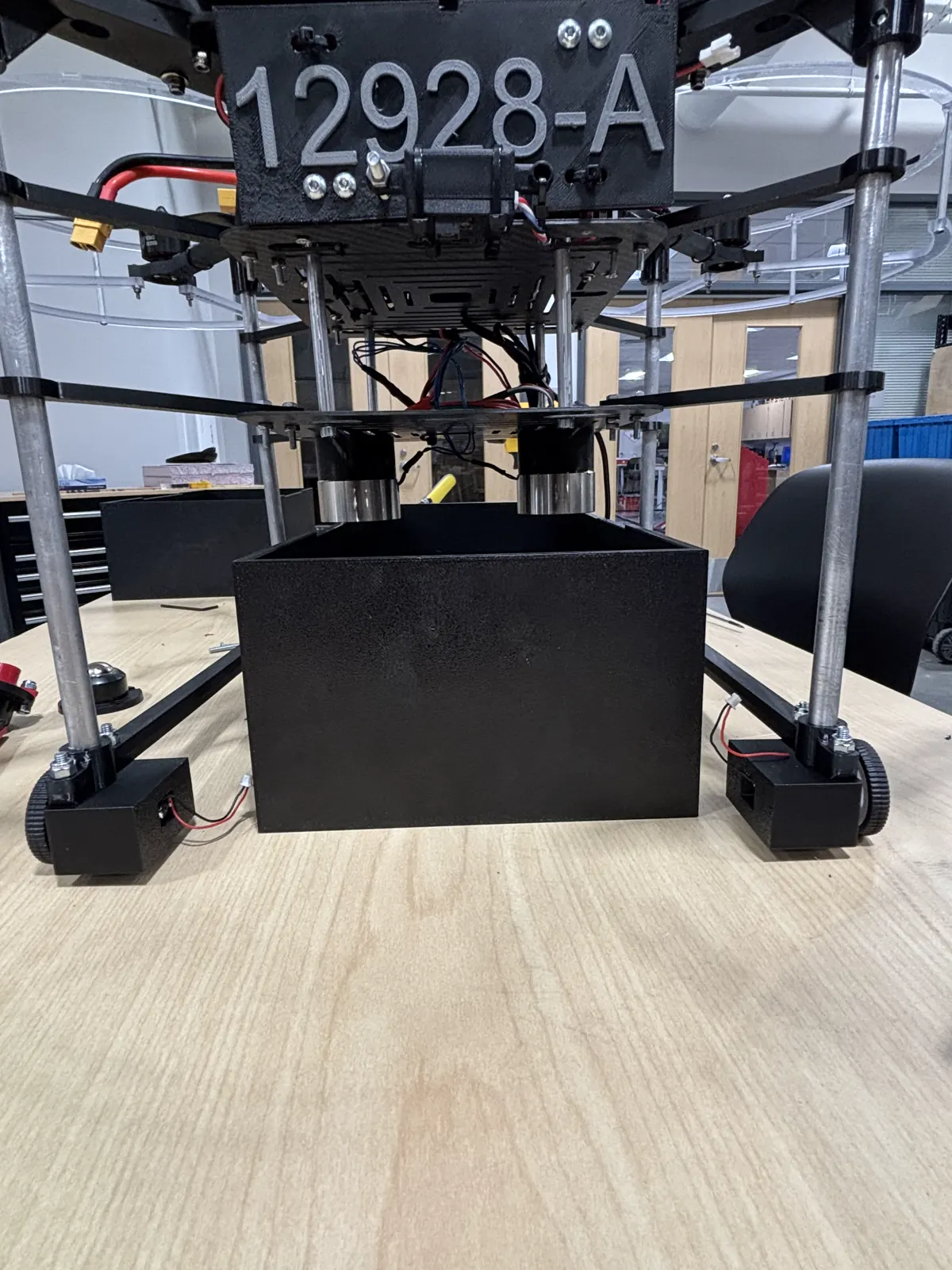 Close-up of a competition drone's payload-release mechanism over a target box