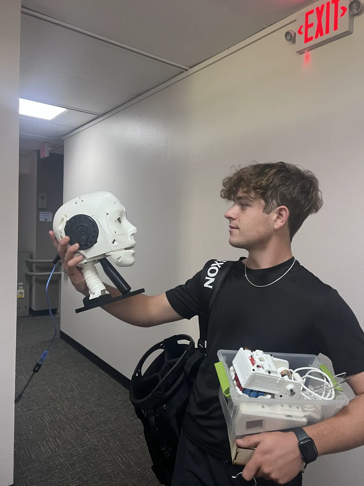 Charlie holding a 3D-printed robotic head he built