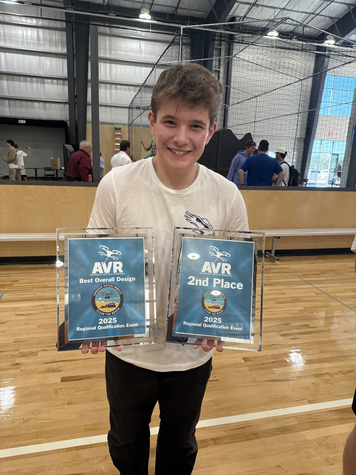 Henry holding two AVR drone competition awards, including Best Overall Design